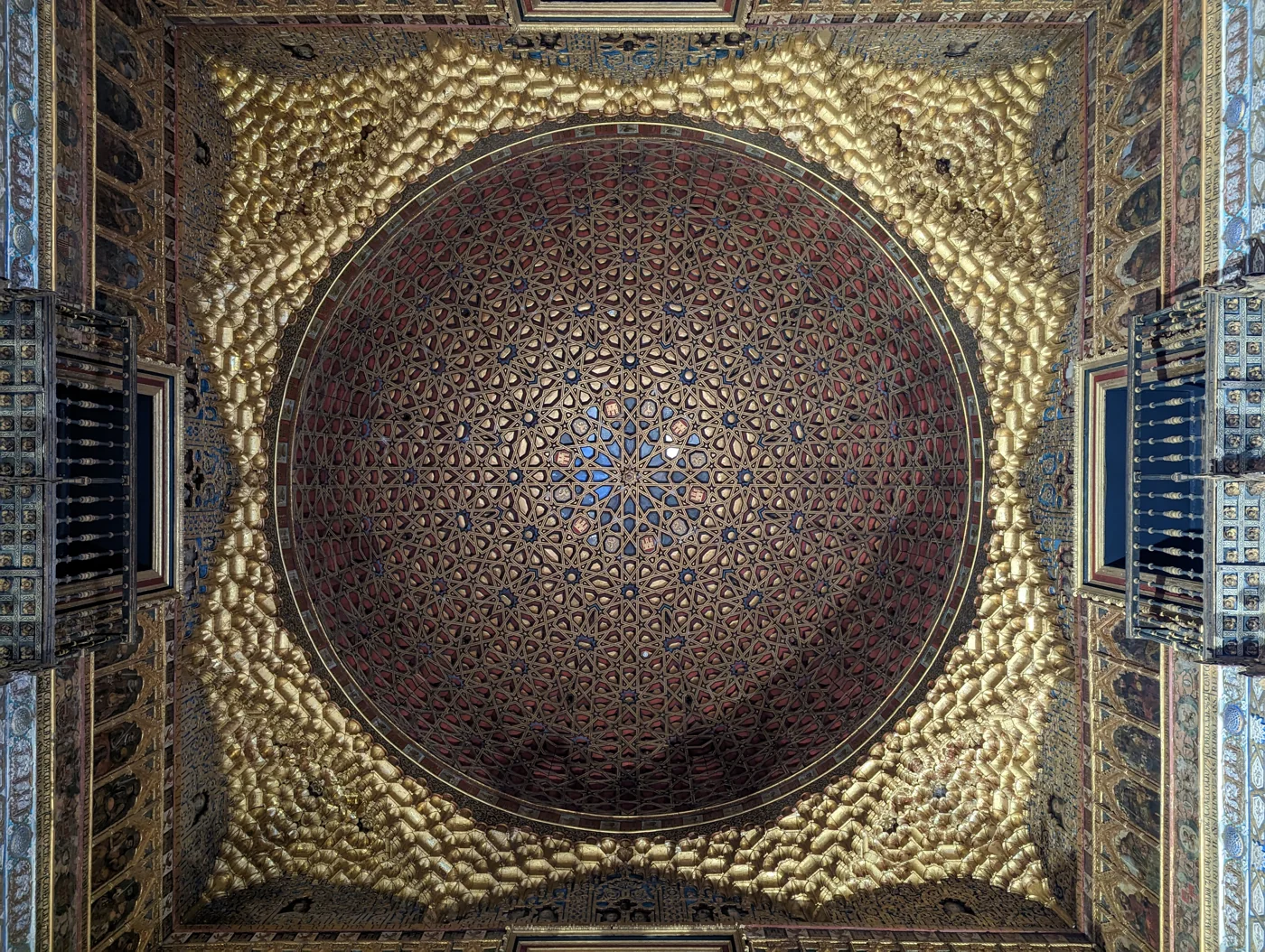 Goldene Ornamente und geometrische Sterne einer gewölbten Decke