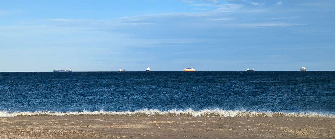 Schiffe am Horizont zwischen Himmel, Meer und Strand