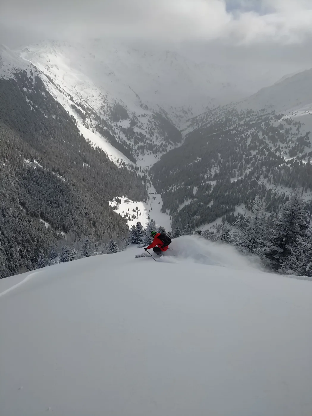 Lukas zieht eine Spur durch den Tiefschnee über einem verschneiten Tal