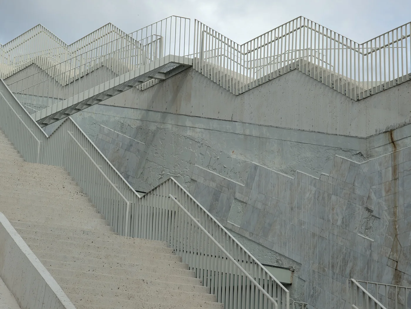 Helle Betontreppen und Metallgeländer bilden geometrische Linien
